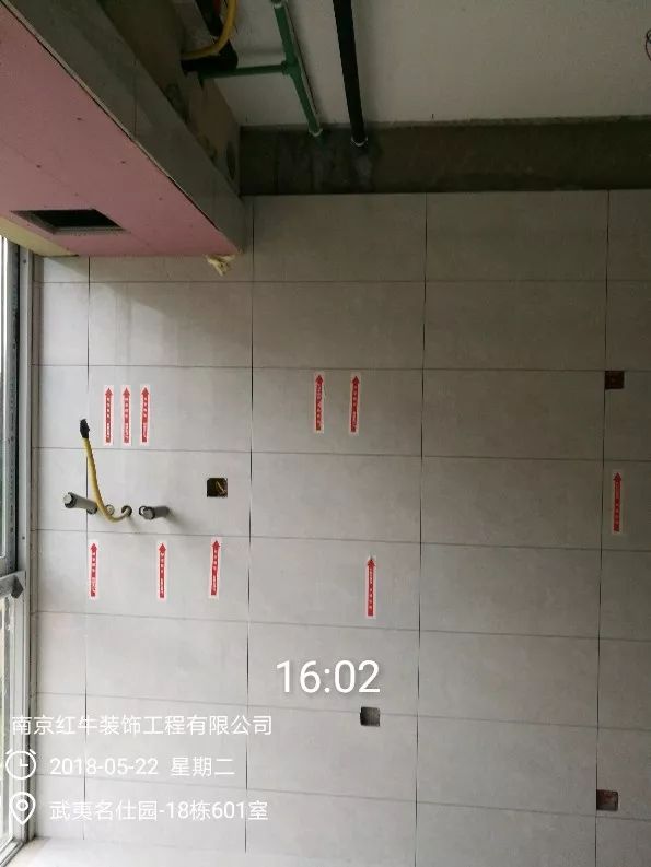 南京武夷名仕園124平米簡(jiǎn)美風(fēng)格裝修  享受家?guī)?lái)的溫度30五月份_墻磚鋪貼完成后，紅牛裝飾的工人會(huì)用專用護(hù)角條對(duì)瓷磚角保護(hù)，用標(biāo)貼標(biāo)出水管、線管走向示意。